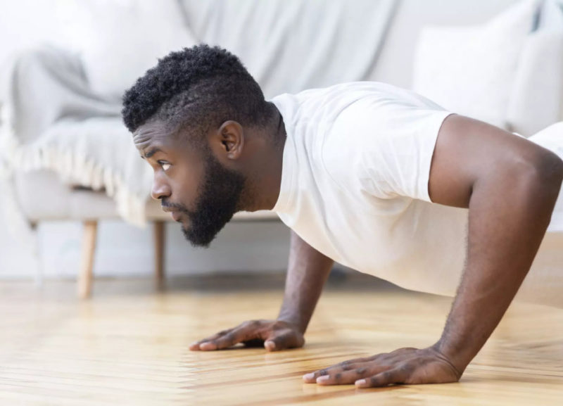 Ragazzo che esegue push up a casa per progredire senza palestra