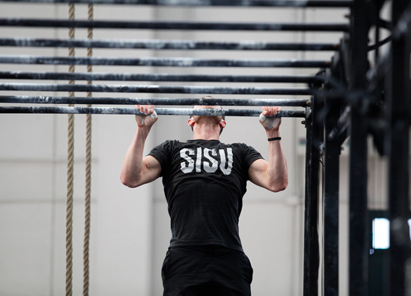 Atleta che esegue pull-up nell'allenamento senza scuse